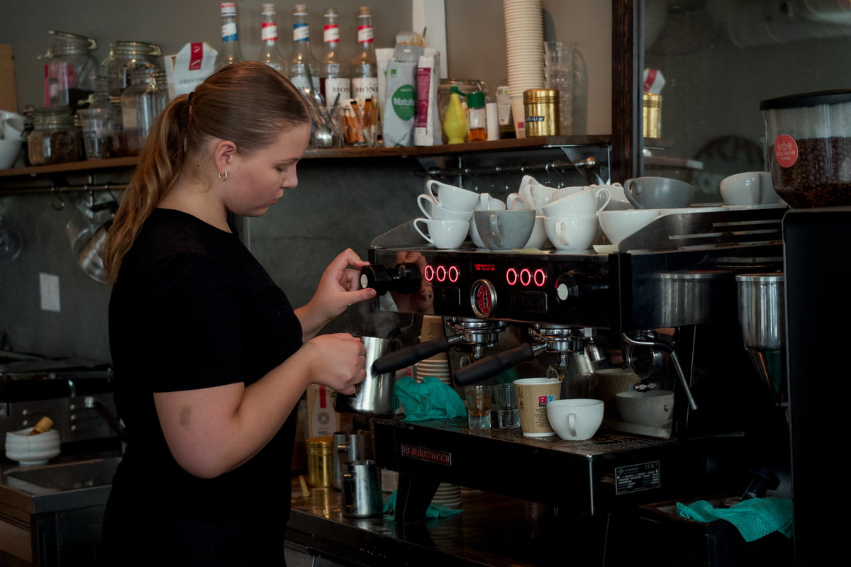 Jente som lager kaffe i cafe