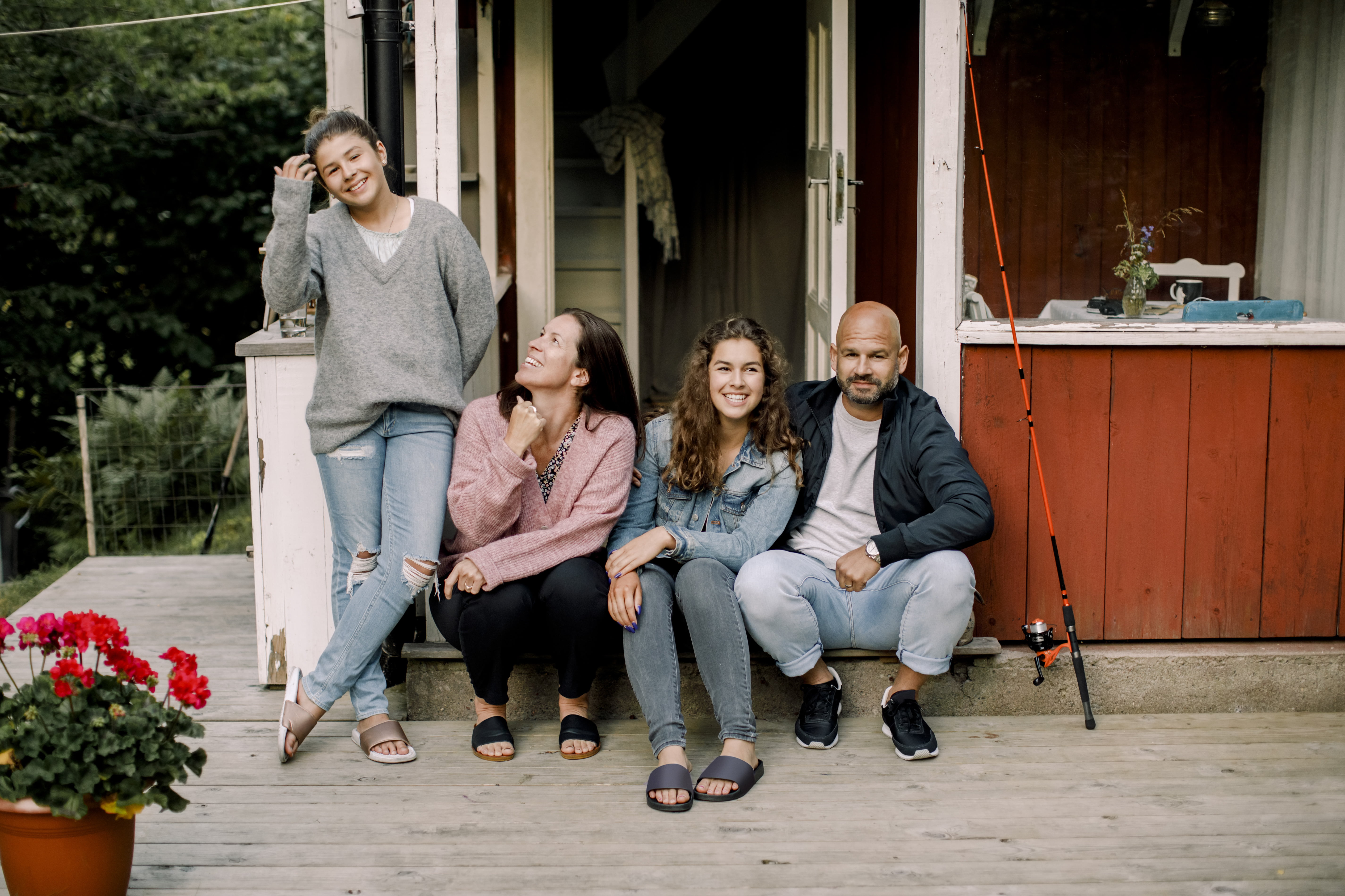 Familie som sitter utenfor en lite hytte