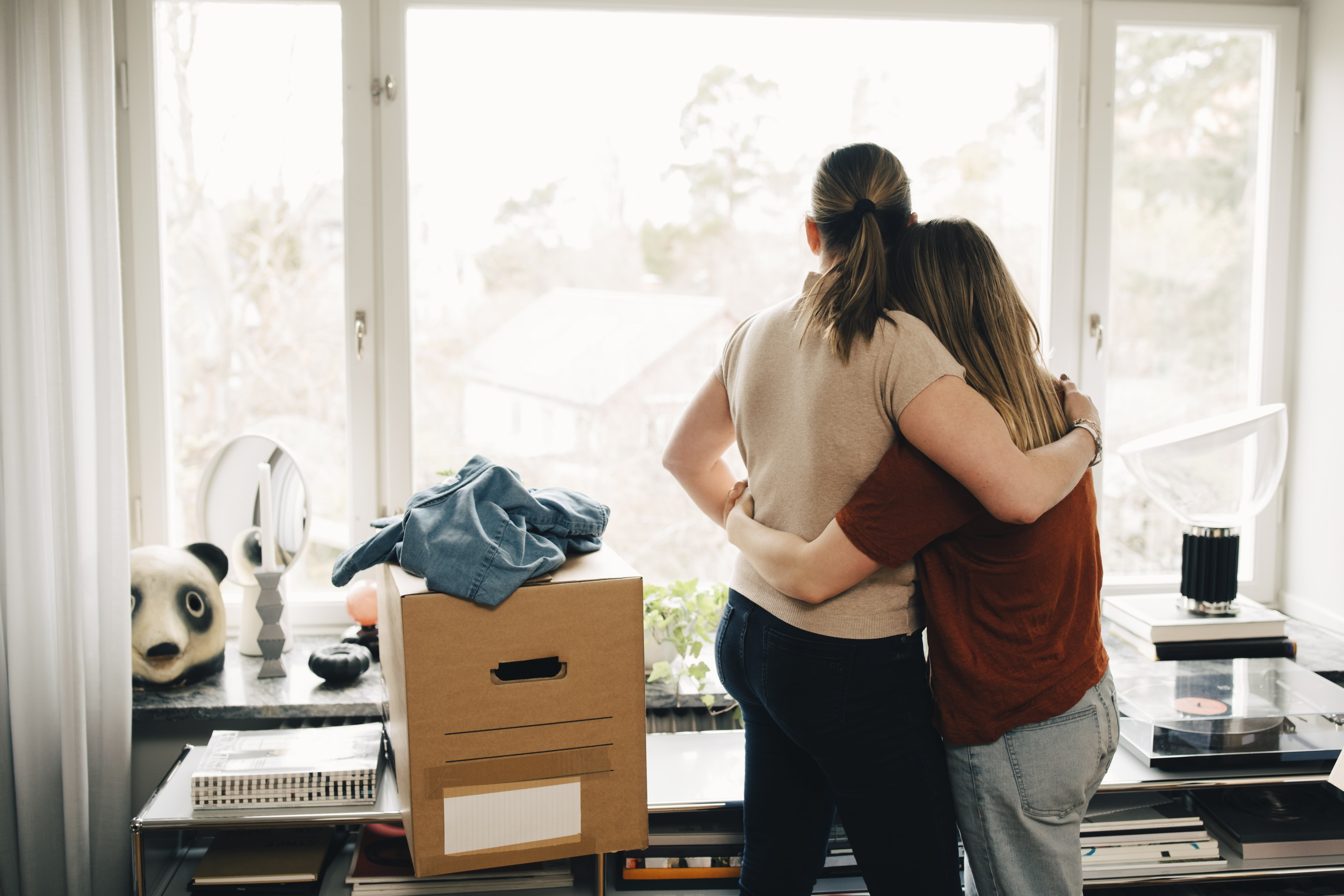 Jente med flytteesker klemmer dame