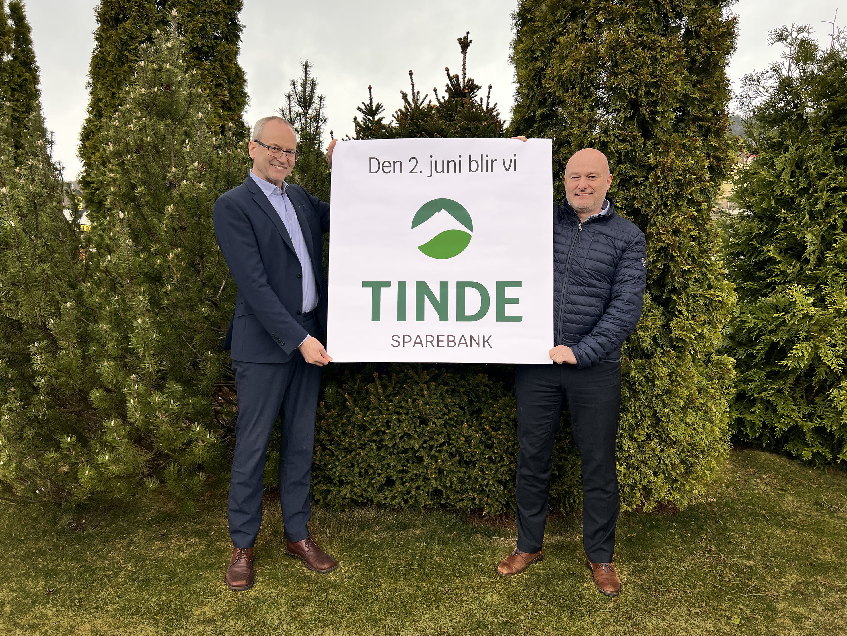 To glade banksjefer med logoplakat